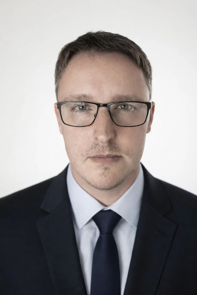 Tim von TiBur Consulting, professionelles Porträt mit Anzug und Brille